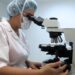 Une chercheuse regardant dans un microscope dans un laboratoire.